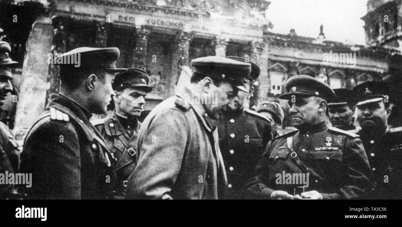 Colonel General Nikolai Erastovich Berzarin (Mitte) mit seinem Personal vor der Ruine des Reichstagsgebäudes. Stadt Berzarin wurde der erste Kommandant von Berlin und für die Verbesserung der Lebensbedingungen, Reinigungsarbeiten und die Wiederbelebung des kulturellen Lebens gekämpft. Als Kommandant war er in der höchsten richterlichen, zivile und militärische Position in Berlin. Kurz danach, Er starb bei einem Unfall. Stockfoto