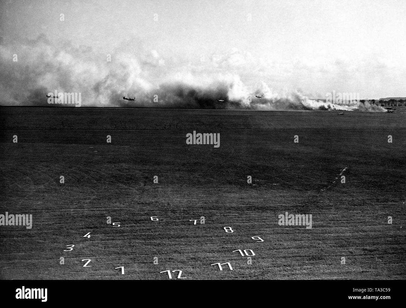 Niedriger Pegel Attack Traning bei einem Manöver der deutschen Luftwaffe. Die Flugzeuge sind Messerschmitt Bf 109. Das Bild war wohl von einer Art Tribüne genommen, weil unter anderem Adolf Hitler besucht auch diese Manöver. Die Nummern in das Feld sollte wahrscheinlich zu den Zuschauern die Anweisungen und den Verlauf der Übung erklären. Stockfoto