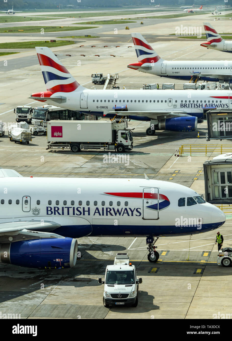 Der Flughafen London Gatwick, ENGLAND - April 2019: Vier British Airways jets am Flughafen Gatwick mit anderen Flugzeugen im Hintergrund geparkt Stockfoto