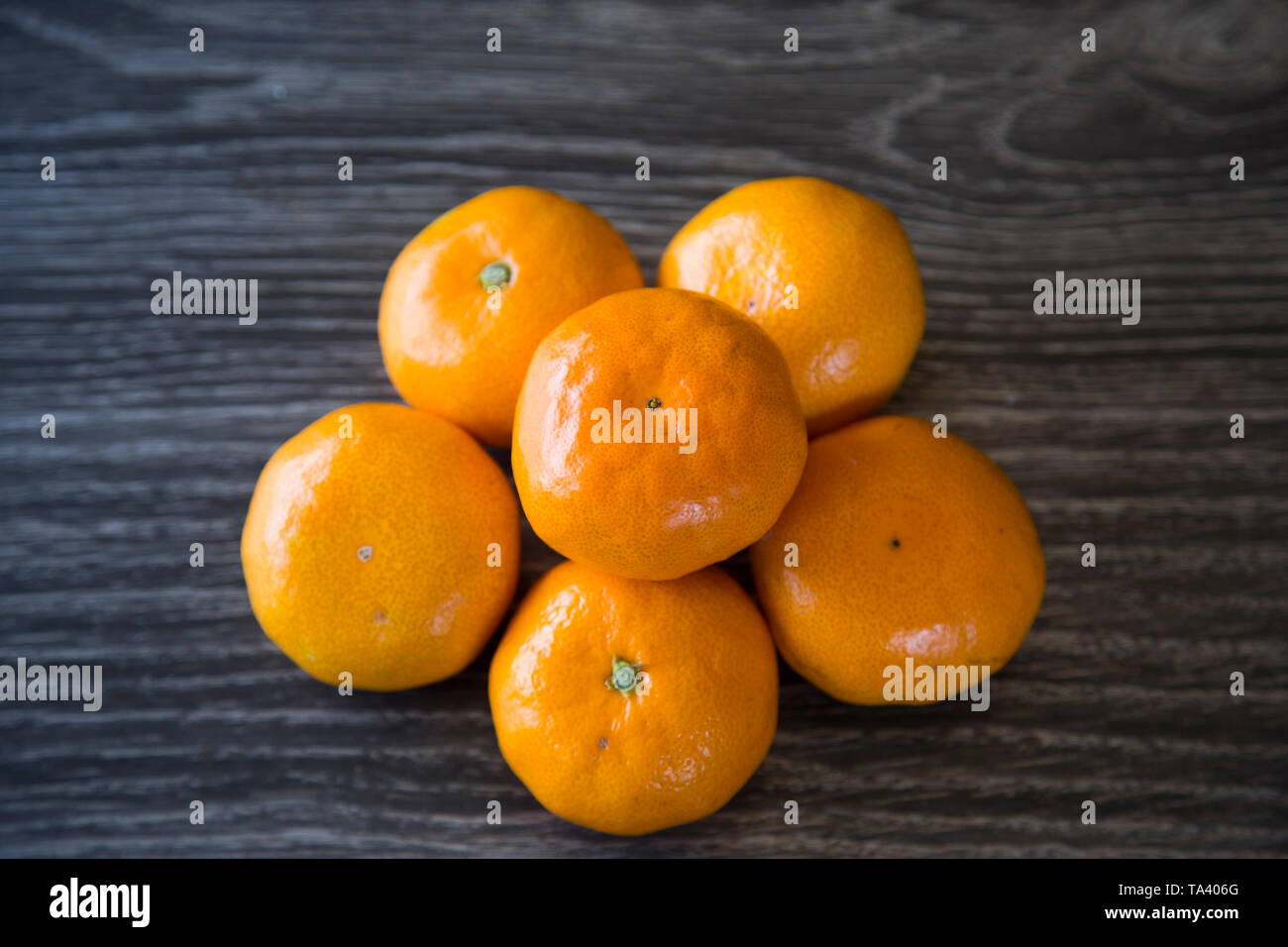 Ein Haufen von ganzen Mandarinen. Schönen Kontrast der Farben auf dunklem Hintergrund. Perfekt für den Winter Immunität und einer leichten gesunden Snack für Kinder. Stockfoto