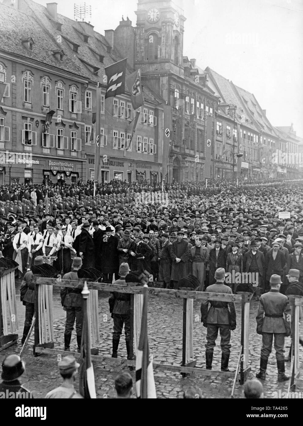 Blick auf den Markt in Cheb, als Konrad Henlein präsentiert den Spaten, um Arbeitnehmer aus dem Sudetenland für die Autobahn Konstruktionen am Dezember 2, 1938. Im Vordergrund, einige Stewards. In der Mitte, die Arbeitnehmer und die Brass Band. Die Häuser sind mit Hakenkreuzfahnen und die Fahnen der SS drapiert. Stockfoto