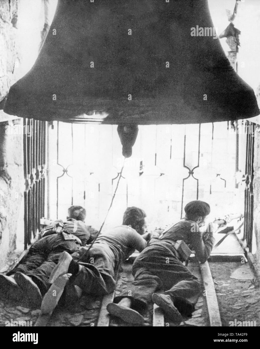 Foto von drei Republikanischen Scharfschützen im August 1936. Die Kämpfer sind Aufnahmen aus einem Fenster auf den Glockenturm der Kathedrale Siguenza, im Nordosten von Madrid. Sie liegen auf dem Boden. Über ihnen hängt die Glocke. Stockfoto