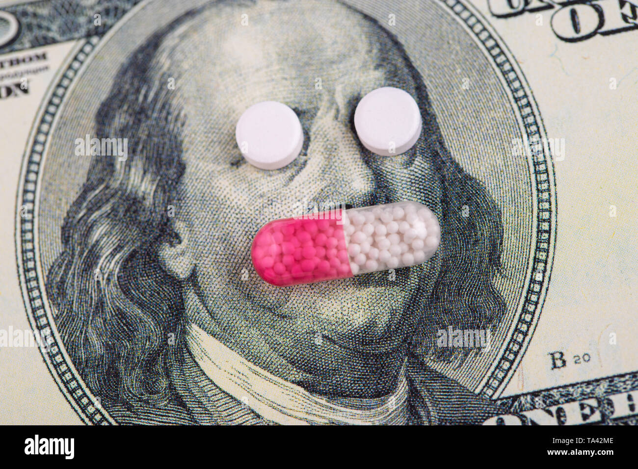 Ein Pillen liegen an Stelle der Augen, auf einer Rechnung von einhundert Dollar close-up. Das Konzept der Versicherung Tiermedizin, hohe Kosten, hohe Kosten für Medikamente. Kostspielig Stockfoto