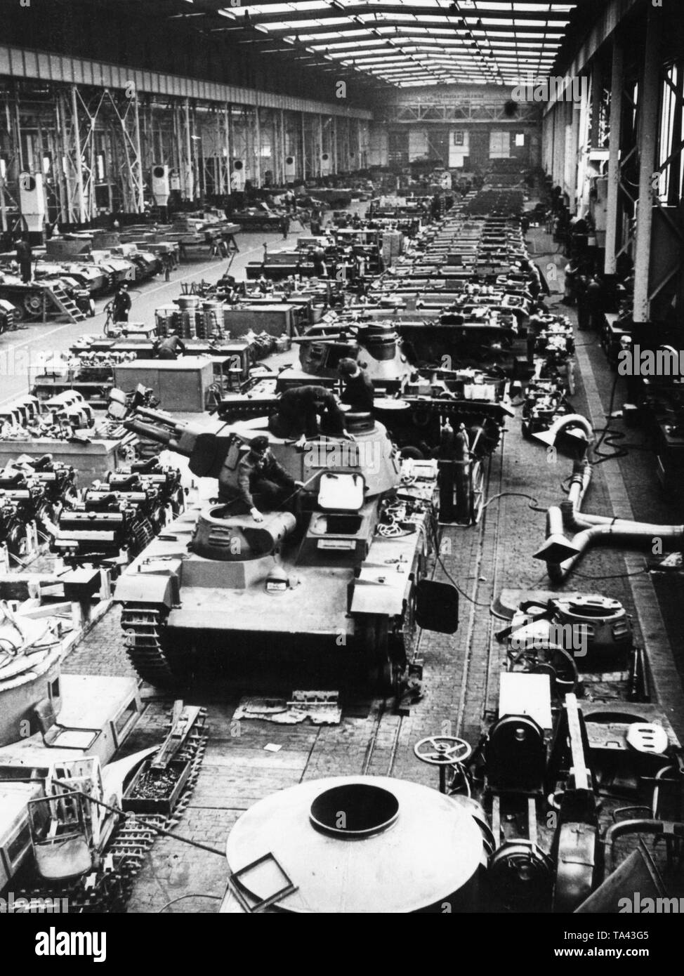 Eine so genannte "Neubaufahrzeug" (neu gebaut) in der Aula der Henschelwerke in Kassel. Dies war die Bezeichnung für den ersten schweren Panzer der Wehrmacht, von denen fünf im Jahr 1935 gebaut wurden. Im Hintergrund ein Panzer III Ausf. E. montiert ist (erkennbar durch das Laufwerk), daher das Bild wahrscheinlich frühestens im September 1939 gebildet wurde. Das Balkenkreuz schlägt auch eine Datierung nach 1939. Stockfoto