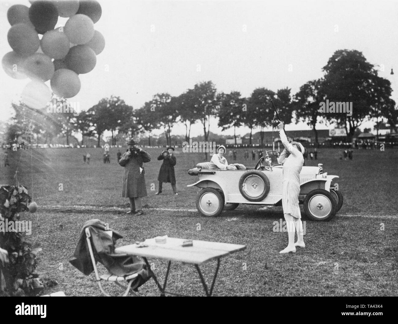 Am 29.05.1926, organisierte der Berliner Automobilklub Fähigkeiten Konkurrenz. Hier eine Frau versucht, einen Ballon, die in der Luft fliegen ist zu schießen. Hinter ihr sitzt eine andere Frau in einen Opel 4/12 PS Laubfrosch, Cabrio, 1924-1926. Stockfoto