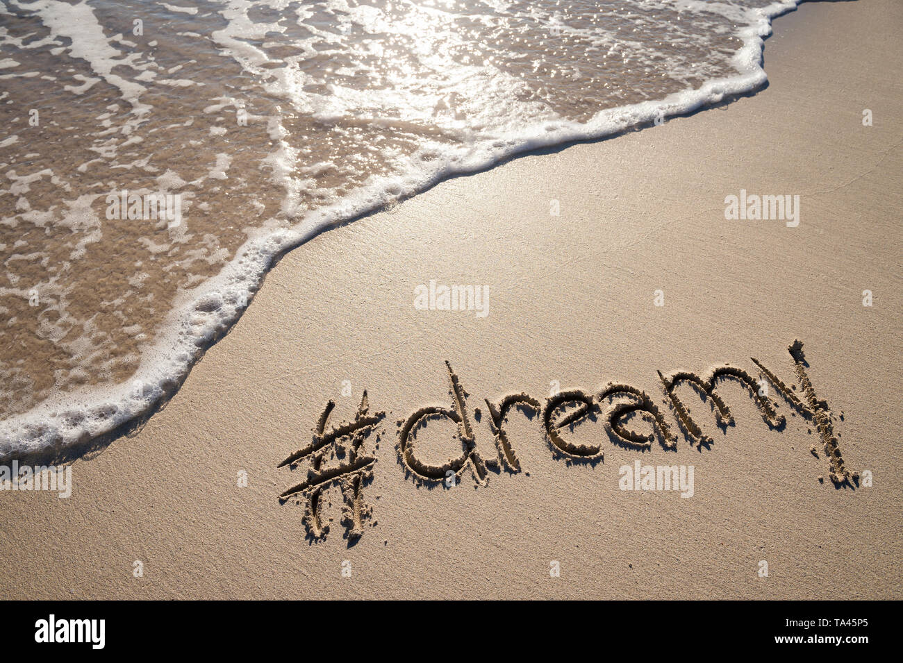Moderne verträumt Nachricht für den Strand mit einem Social Media - freundliche hashtag in glatten Sand geschrieben mit ankommenden Welle Stockfoto