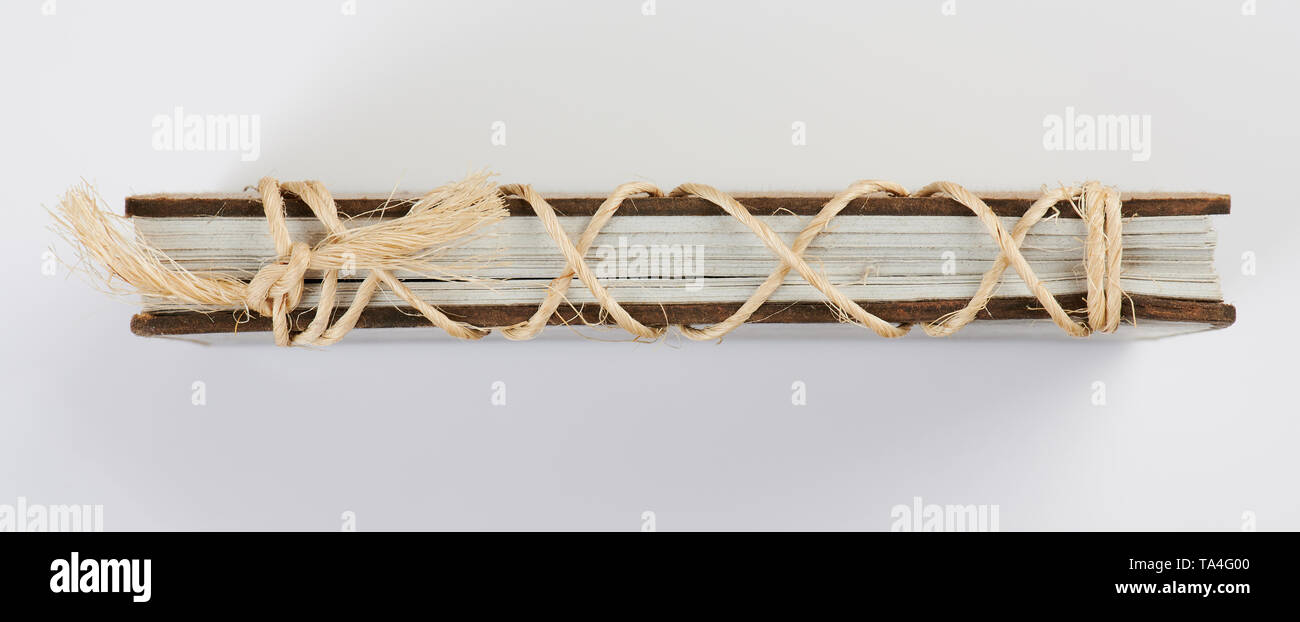 Seitenansicht des Buch mit Seil auf weißem Hintergrund Stockfoto