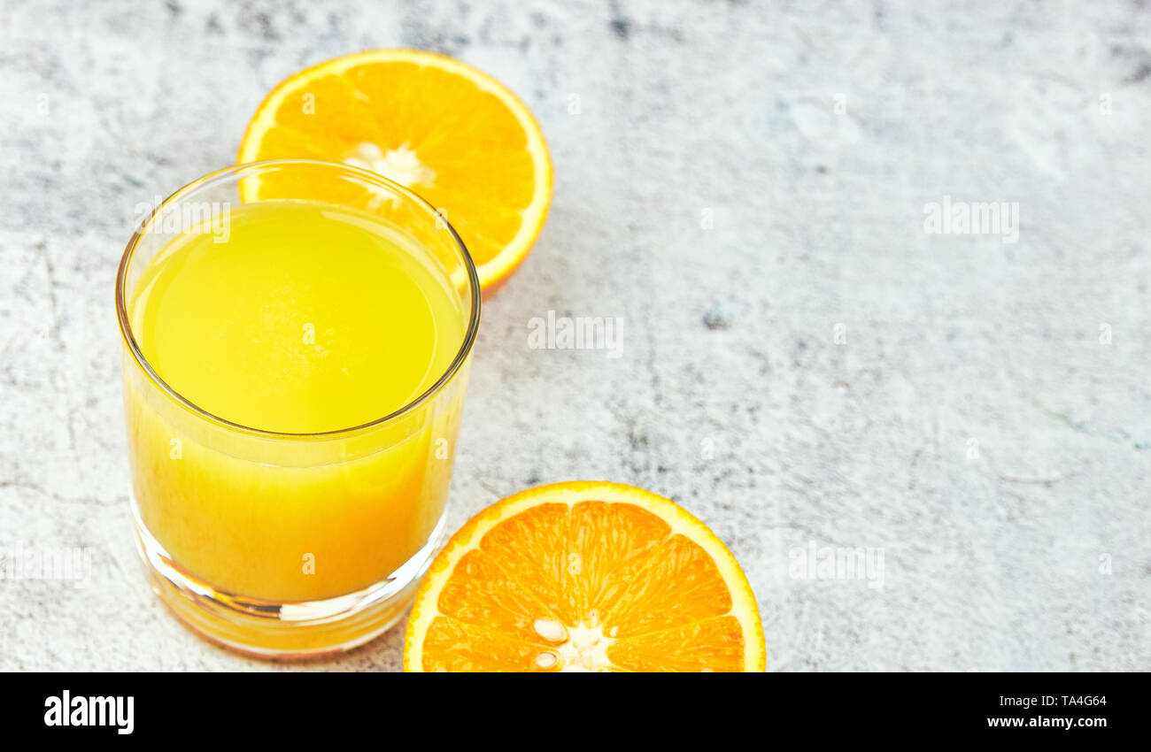 Noch immer leben Glas frisch gepresster Orangensaft auf konkreten Hintergrund mit Filter. Stockfoto