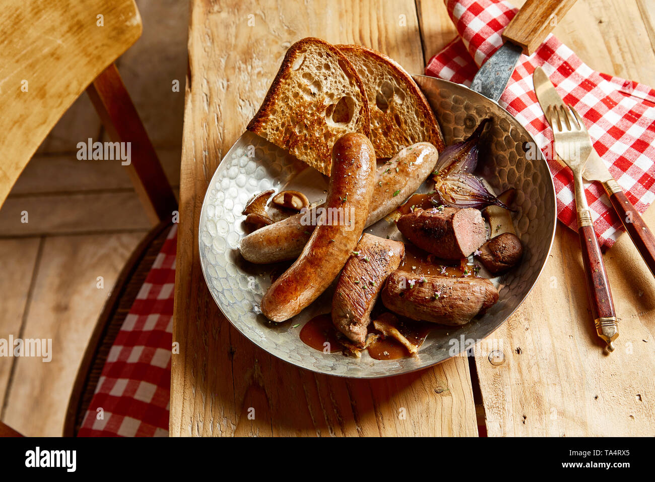 Mit der sortierten Wild Wild Fleisch mit saftigen Wildschwein und Reh Filets und würzigen Würstchen in einer Schüssel mit Soße und geröstetem Roggen Brot Stockfoto