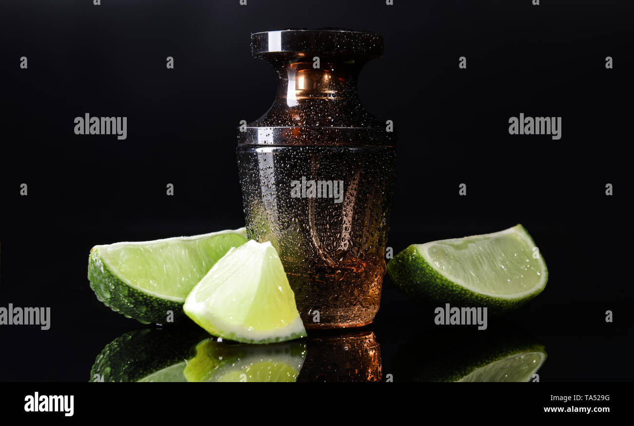 Flasche Parfüm und Zitrusfrüchte auf dunklem Hintergrund Stockfoto