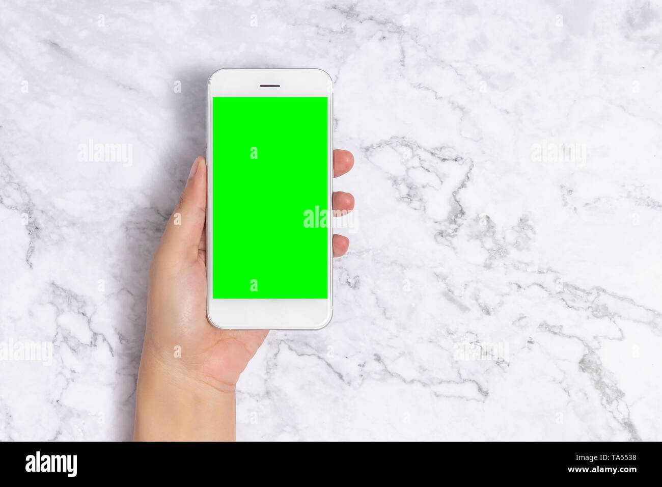Nahaufnahme, Frau, Hand, white Handy mit leeren Bildschirm Grün auf weißem Hintergrund, Frontansicht mit kopieren. freistellungspfad gehören Stockfoto