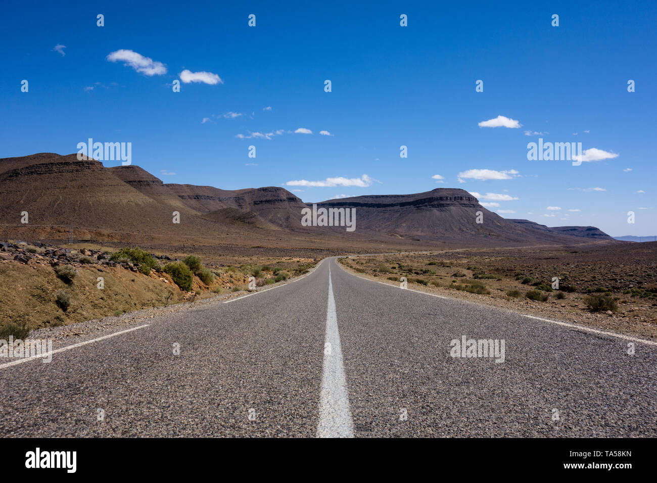 Marokkanischen Autobahn mit einem felsigen Wüstenlandschaft auf einer Straße - Reise von Marrakesch, Fes, Marokko Stockfoto