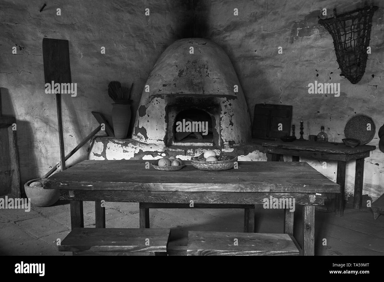 Alten spanischen Stil aus einer Küche mit Kamin und Holz Tisch am La Purisima Mission in Lompoc, Kalifornien. Stockfoto