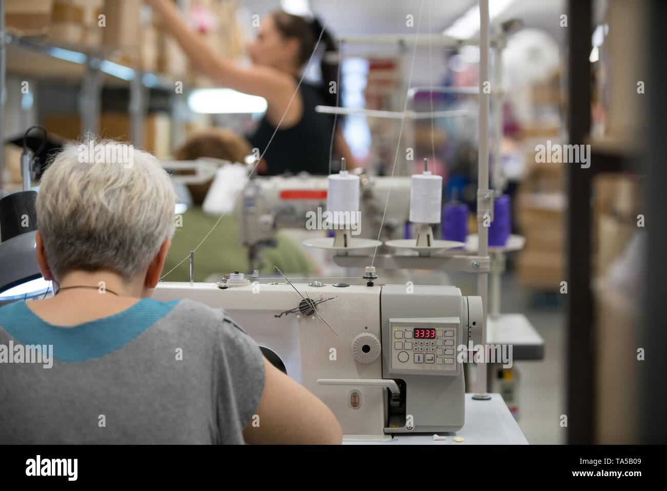 Frau nähen in der Werkstatt line Bereich Stockfoto