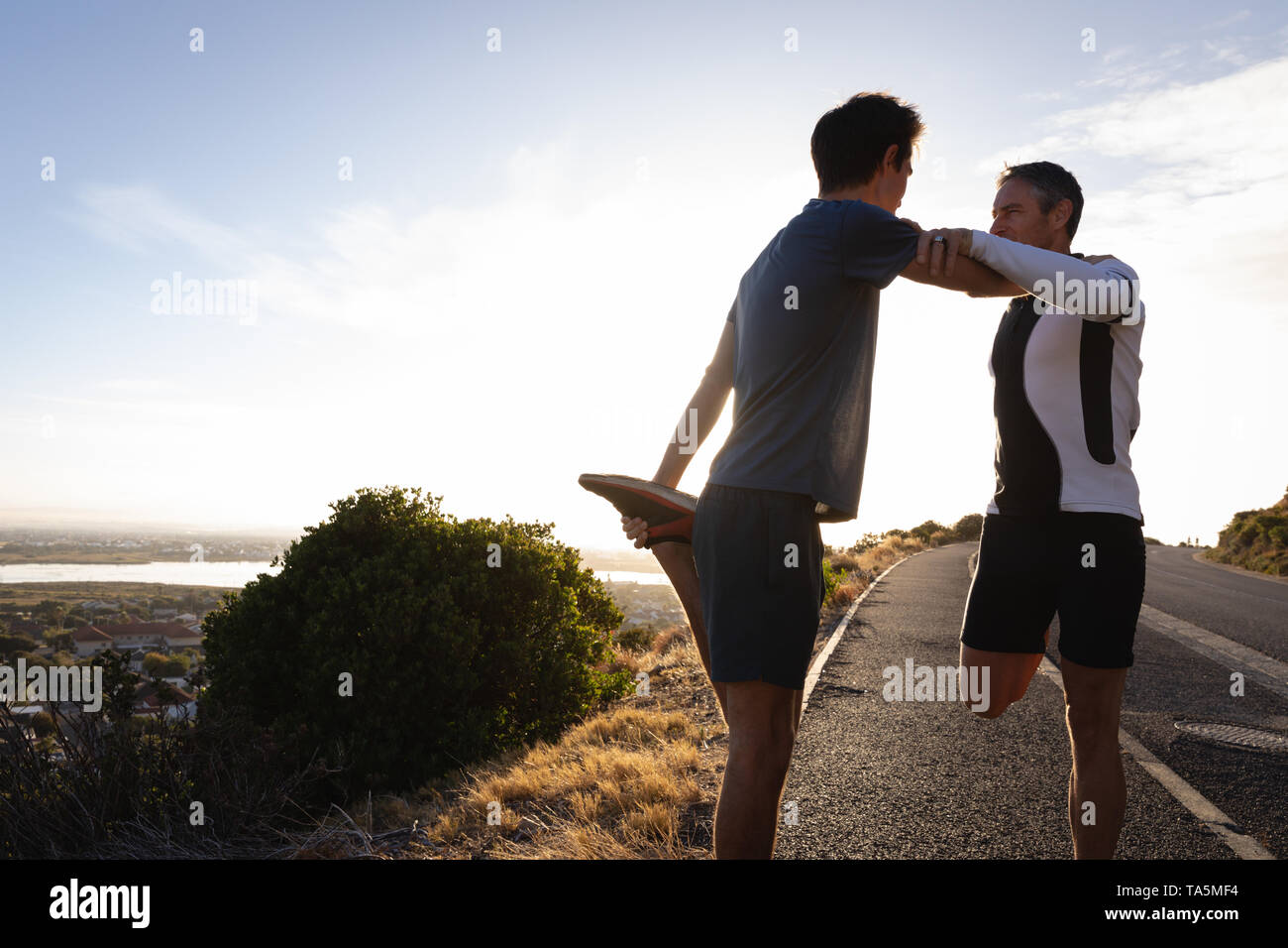Vater und Sohn zu tun stretching Übung auf der Straße Stockfoto