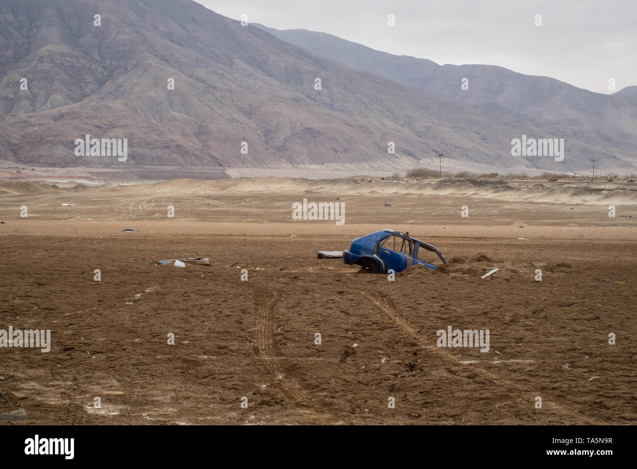 Blaues Auto unter der Erde nach einem Hochwasser in Portezuelo, Chile begraben. Naturkatastrophen Stockfoto