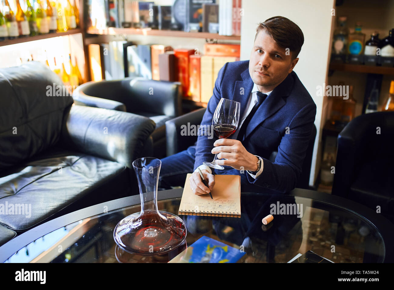 Elegante Mann im blauen Anzug Auswahl Wein, das Essen Kompliment. Foto in der Nähe. Stockfoto