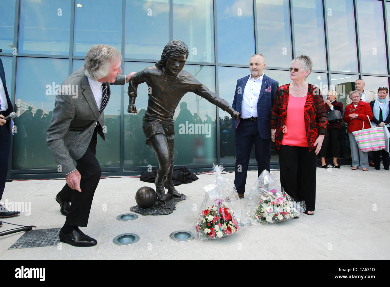 Belfast, County Antrim, Nordirland, Irland. 22. Mai, 2019. Pat Jennings (links) ehemalige Nordirland footballer und Robert Kennedy (Mitte-NI-Fußball-Fan) verbindet George Best' Schwester Barbara McNarry nachdem Sie eine Bronzestatue von George an der Olympia Leisure Centre in Belfast auf, was 73 der Fußball-Legende Geburtstag gewesen wäre, vorgestellt. Credit: Paul McErlane/Alamy leben Nachrichten Stockfoto