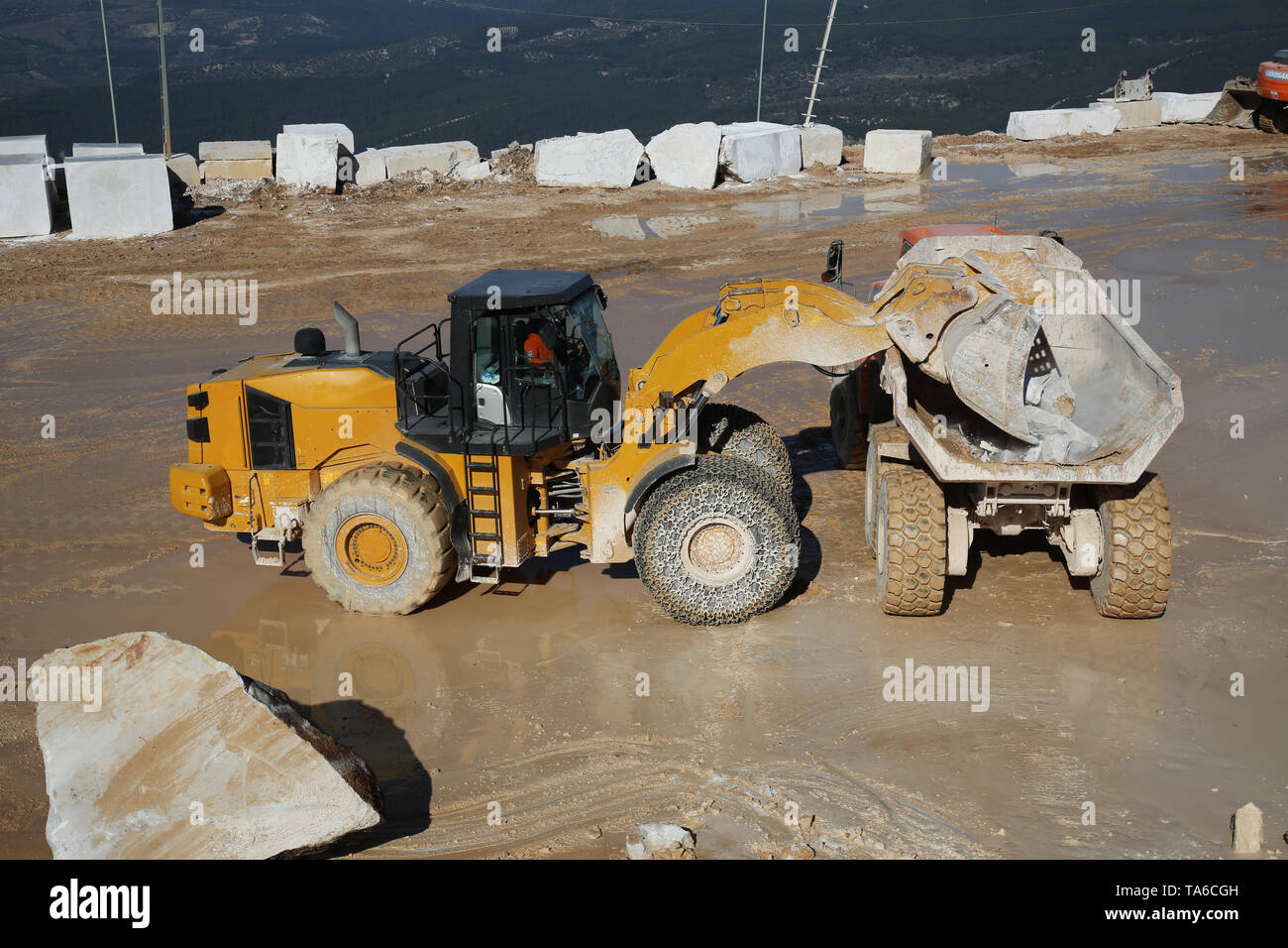 Ein großer Lader Maschine arbeiten am Steinbruch. Ein Lader laden Marmor blockieren. Schwere Maschinen arbeiten an Bergbau Steinbruch. Stockfoto