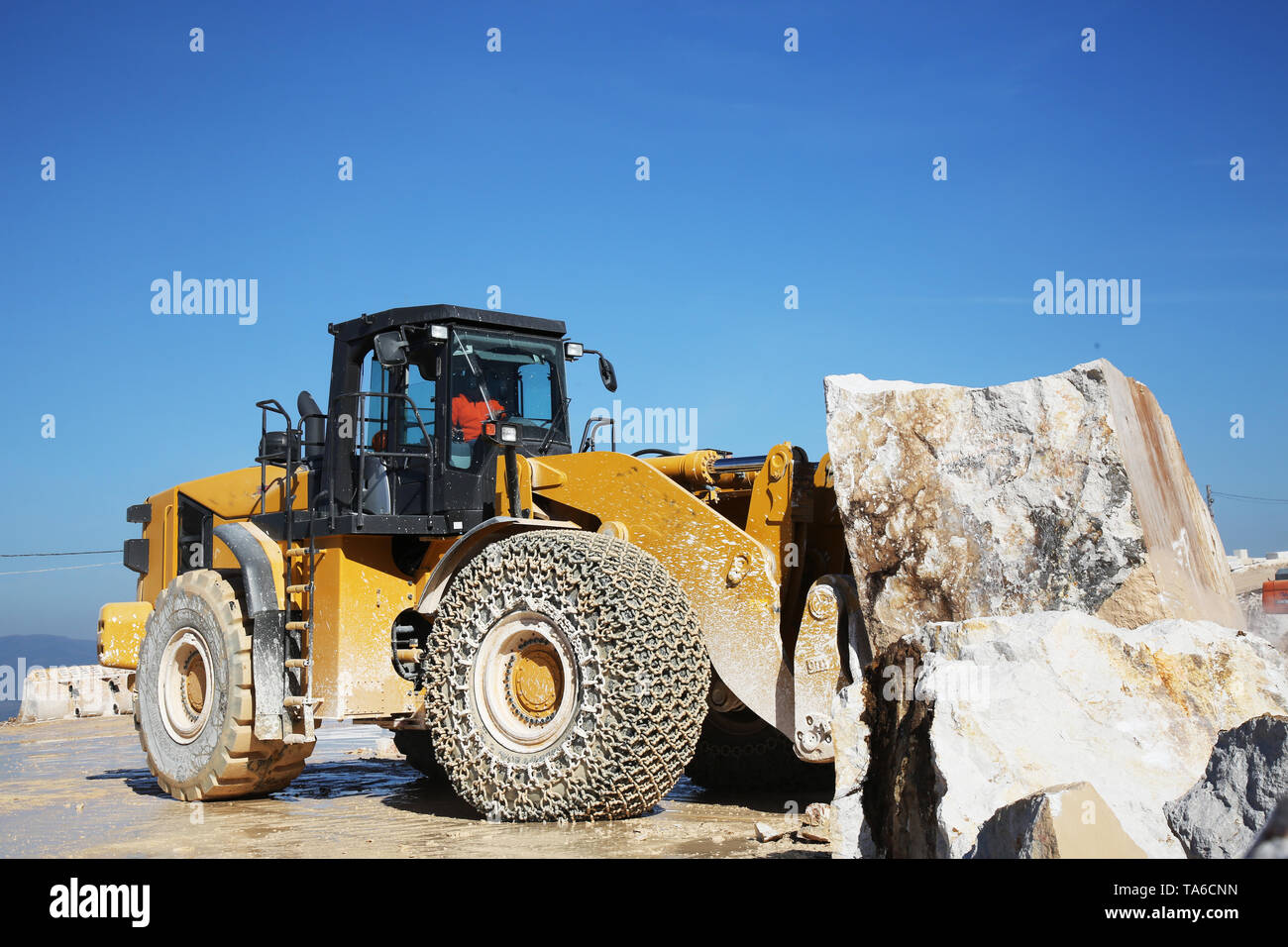 Ein großer Lader Maschine arbeiten am Steinbruch. Ein Lader laden Marmor blockieren. Schwere Maschinen arbeiten an Bergbau Steinbruch. Stockfoto