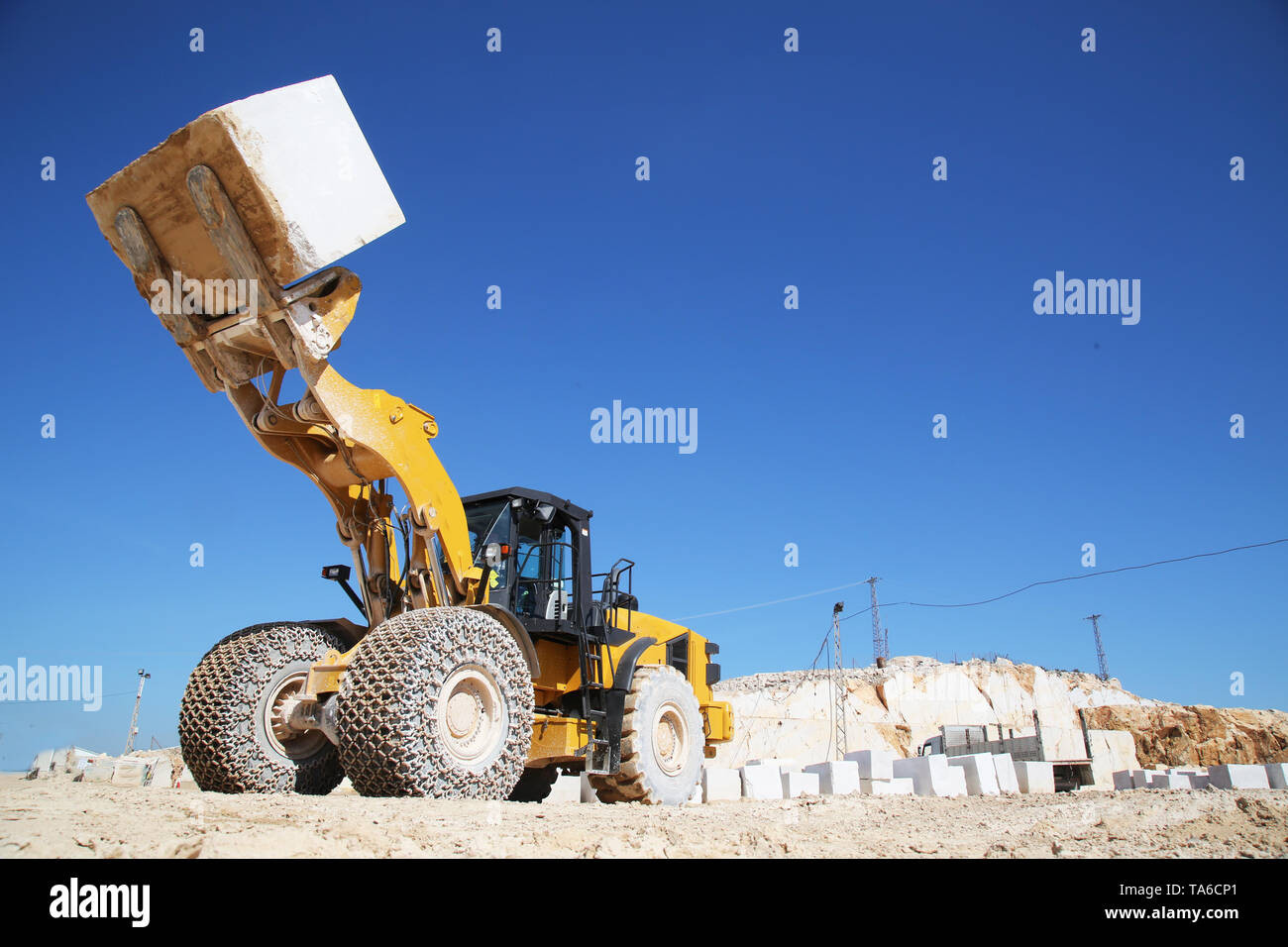 Ein großer Lader Maschine arbeiten am Steinbruch. Ein Lader laden Marmor blockieren. Schwere Maschinen arbeiten an Bergbau Steinbruch. Stockfoto