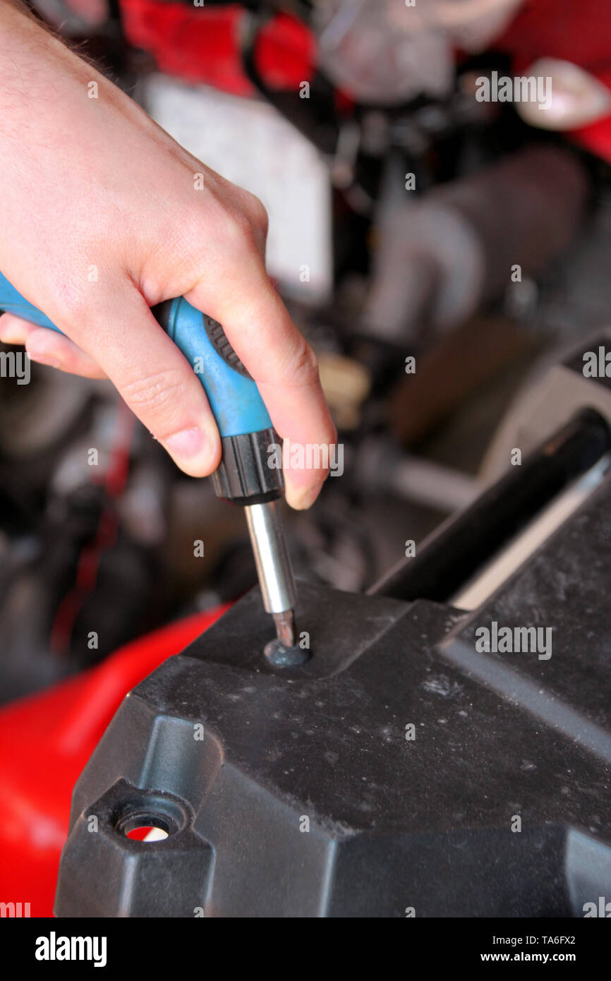Kfz Mechaniker und Meister ist, schrauben Sie eine Schraube mit blauen  Schraubendreher in automechanics Werkstatt. Es wurden die Hände der  Automechaniker Stockfotografie - Alamy