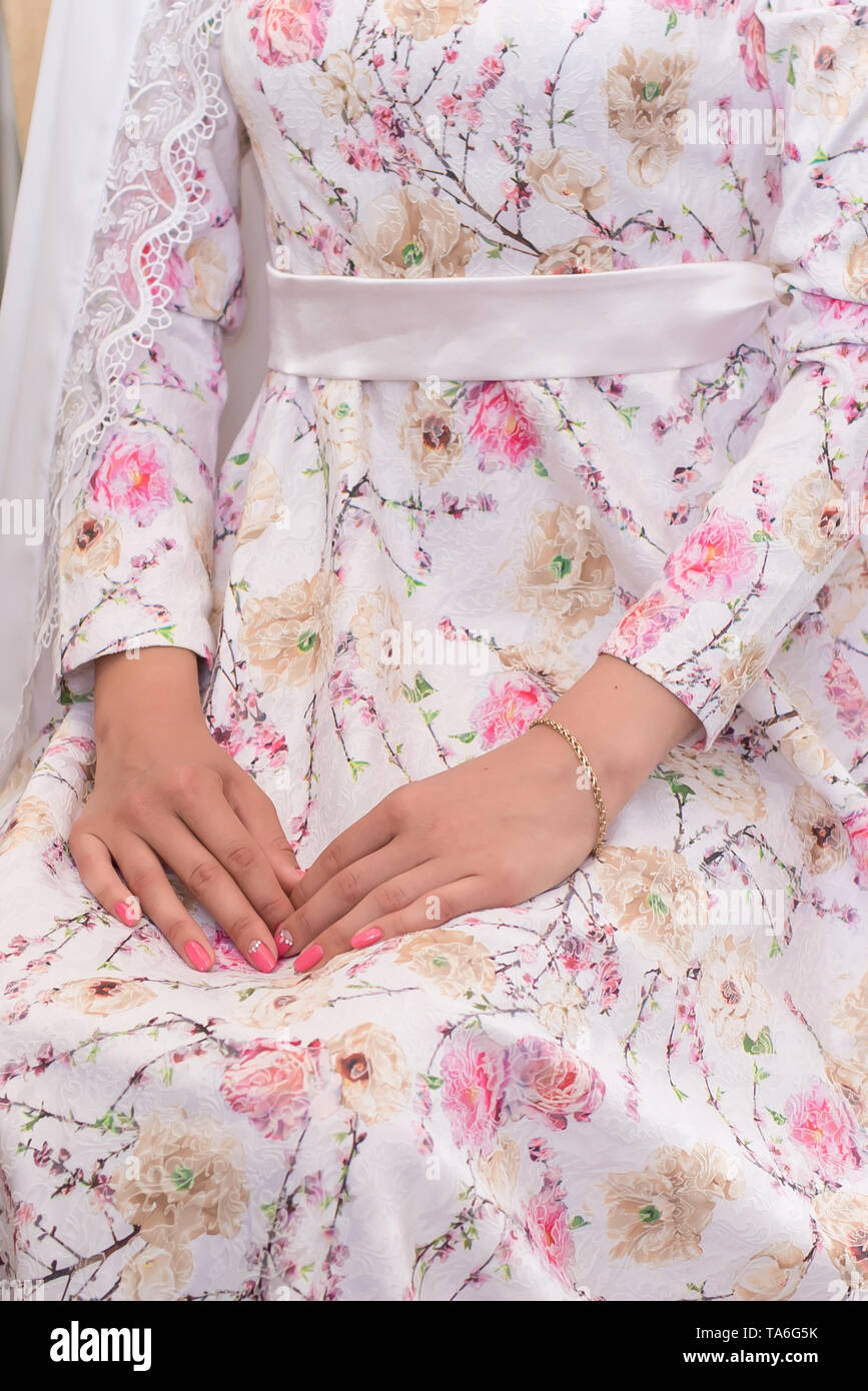 Muslimischen braut Vorsichtig legte ich meine Hände auf ein wunderschönes Kleid mit rosa Blumen Stockfoto