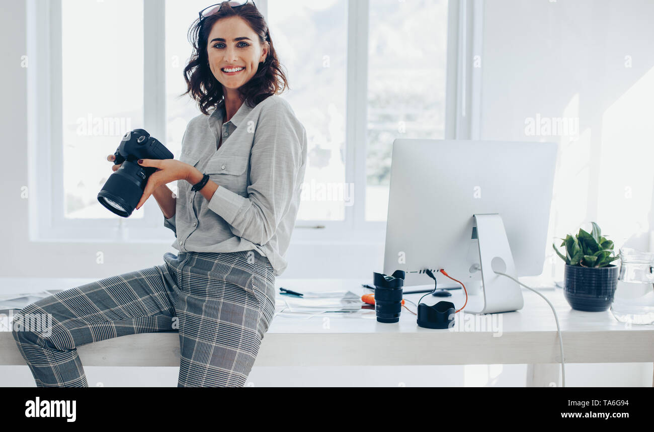 Professionelle Fotografen mit Ihrer Kamera. Kaukasische Frau mit Digitalkamera im Amt. Stockfoto