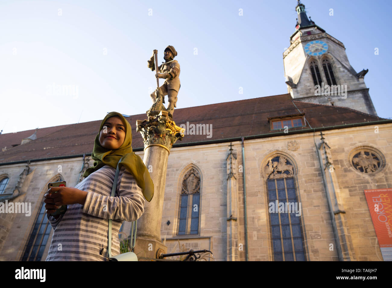 Tübingen/Deutschland: 30. Juli 2018: Eine muslimische Reisende Frau glücklich aussieht, Wandern auf den Bürgersteigen der Stadt Tübingen in der Nähe der St. George's College Stockfoto