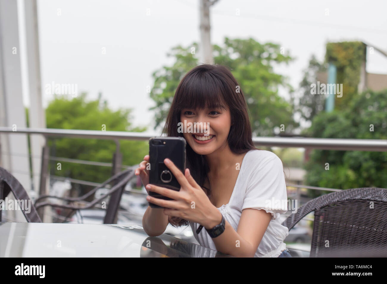 Hübsche asiatische Frau genießen mit Handys im Restaurant Stockfoto