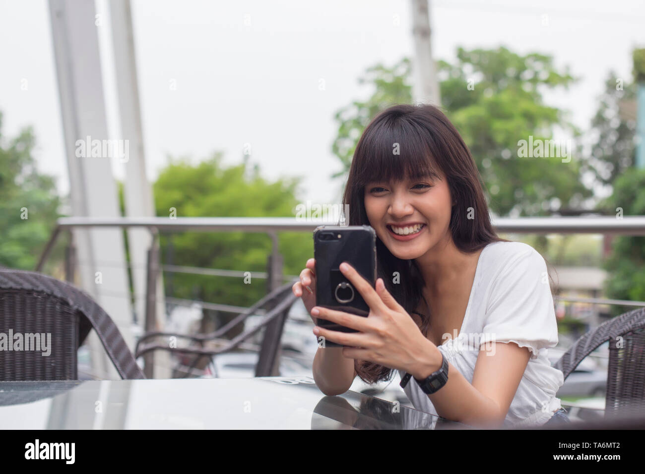 Gerne asiatische Frau mit smart phone in Coffee Shop Stockfoto