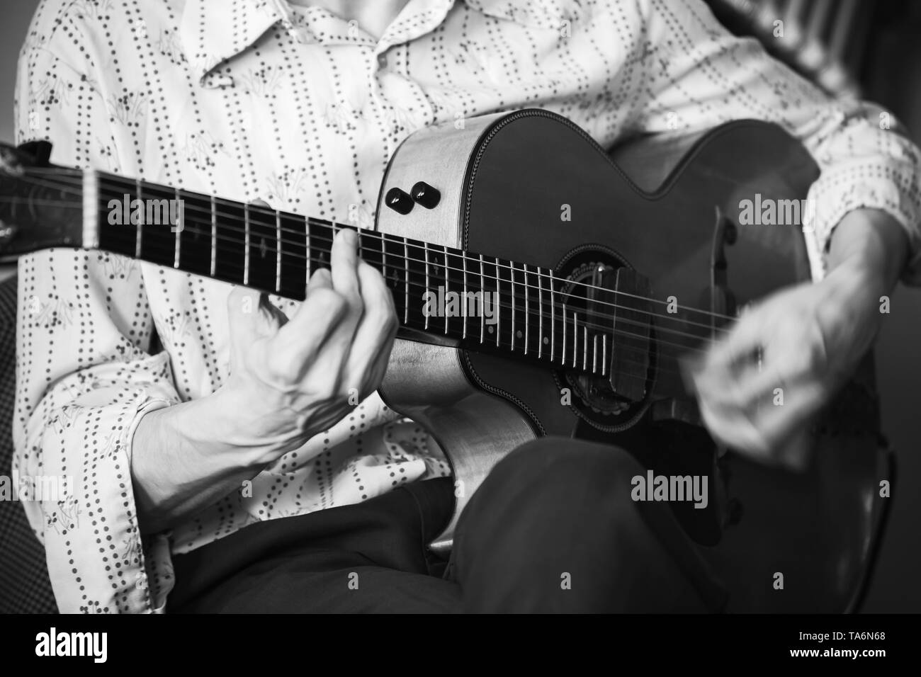 Eine akustische Gitarre player, Nahaufnahme mit weichen selektiven Fokus, Schwarz und Weiß Stockfoto