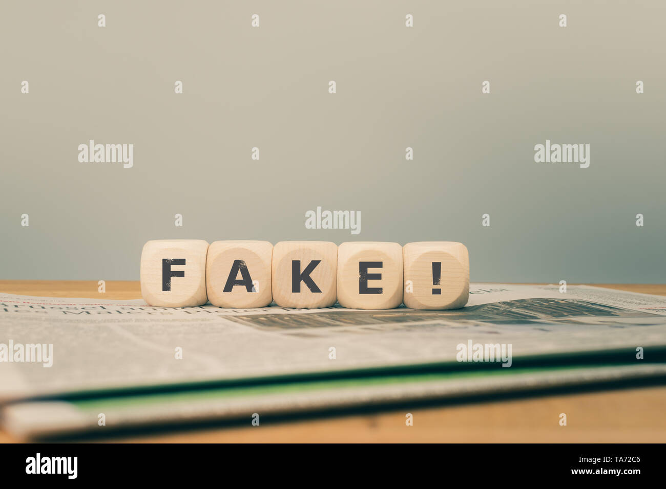 Konzept für gefälschte Nachrichten. Würfel auf eine Zeitung Form das Wort "FAKE!" platziert. Stockfoto