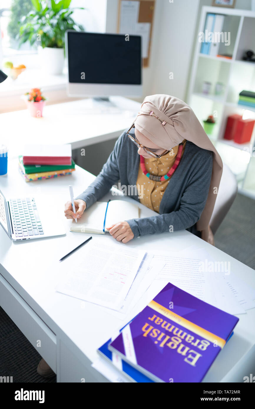 Junge Englischlehrerin Notizen nach dem Arbeitstag Stockfoto