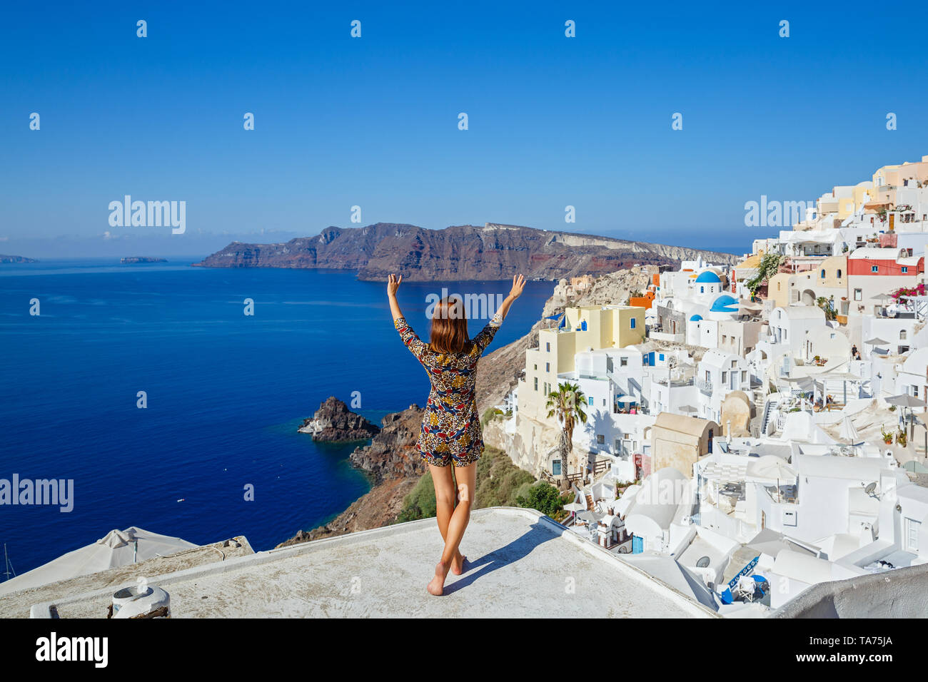 Junge schöne Frau auf einem Hügel und auf das Meer, die Insel Santorini, Griechenland Stockfoto