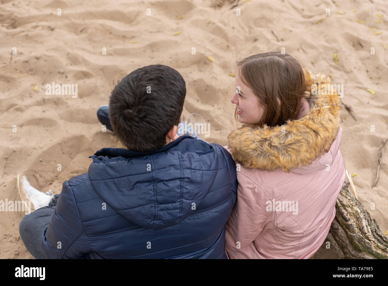 Ein verliebtes Paar sitzt im Sand Stockfoto