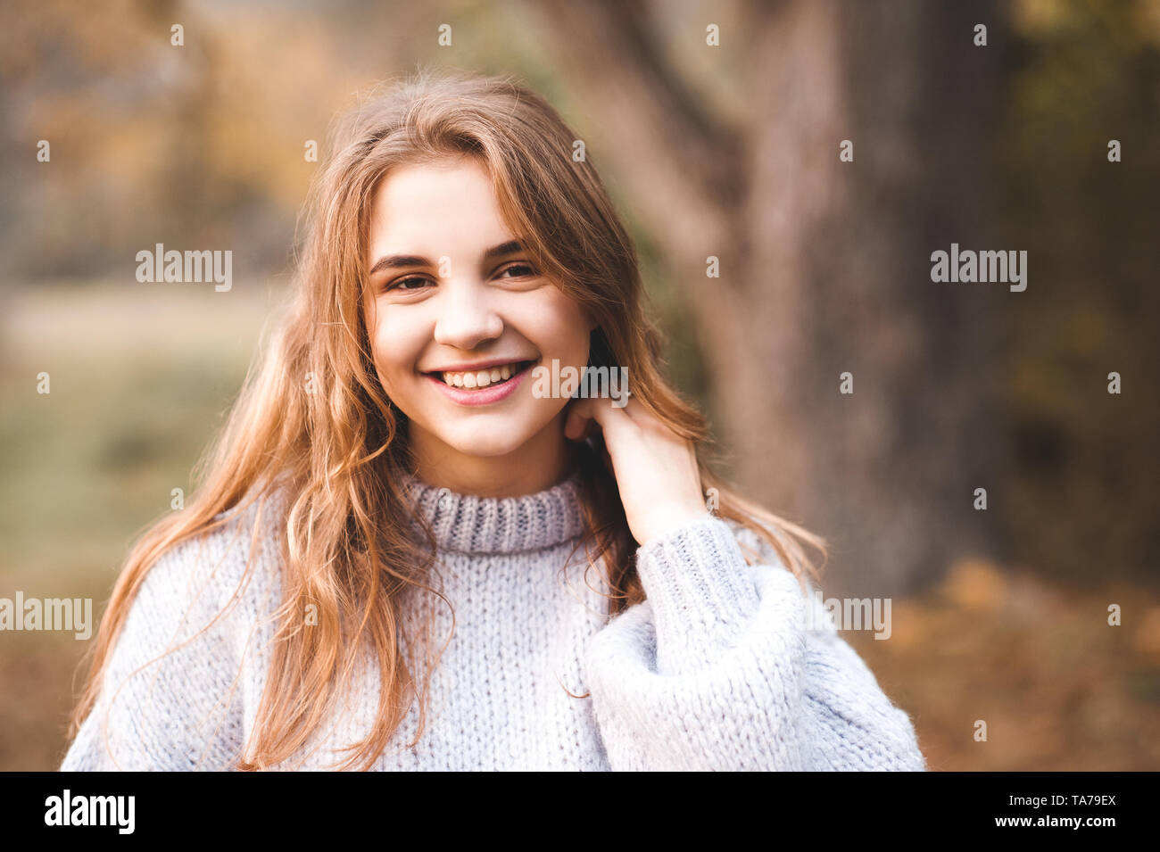 Lächelnd jugendlich Mädchen 16-17 Jahre alten tragen gestrickte Pullover in Park closeup posieren. Portrait von Happy Teenager. Mit Blick auf die Kamera. 20. Stockfoto