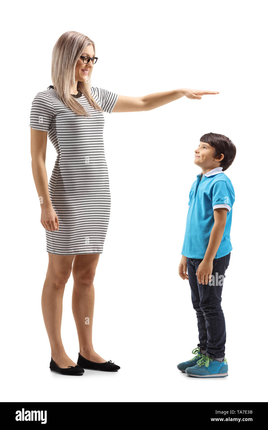 Volle Länge Schoß einer Frau und deutete mit der Hand und zeigt die Höhe eines Jungen auf weißem Hintergrund Stockfoto
