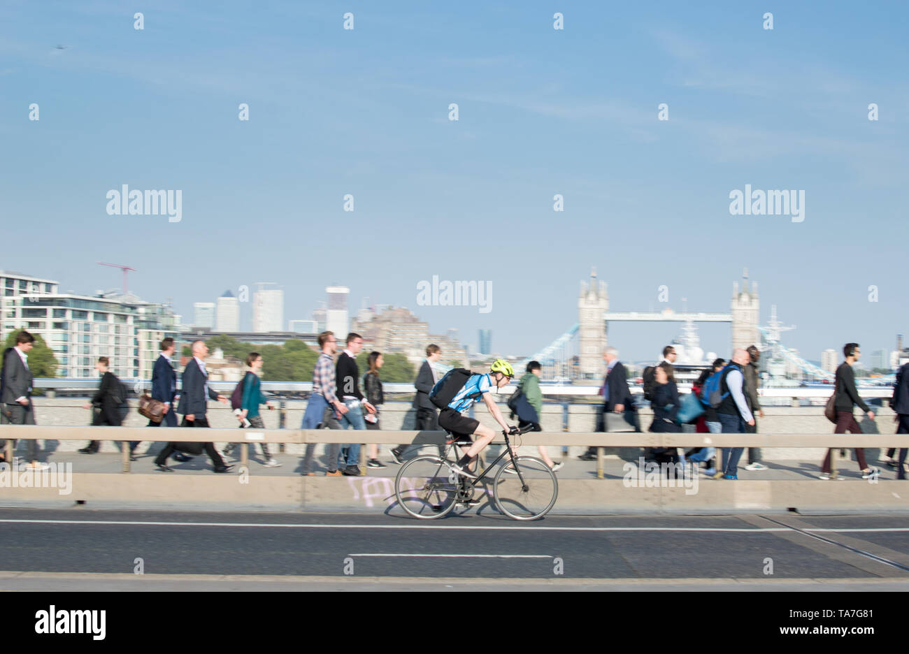 Stadt Radfahrer (Motion Blur) crossing London Bridge mit Blick auf die Tower Bridge im Hintergrund Stockfoto