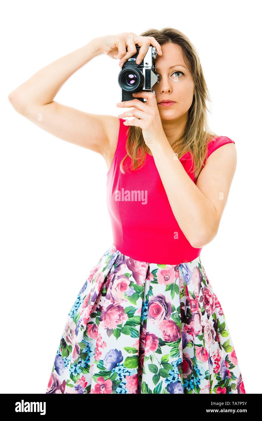 Eine Frau Fotograf in Magenta Kleid mit alten analogen Kamera nehmen Schuß Stockfoto