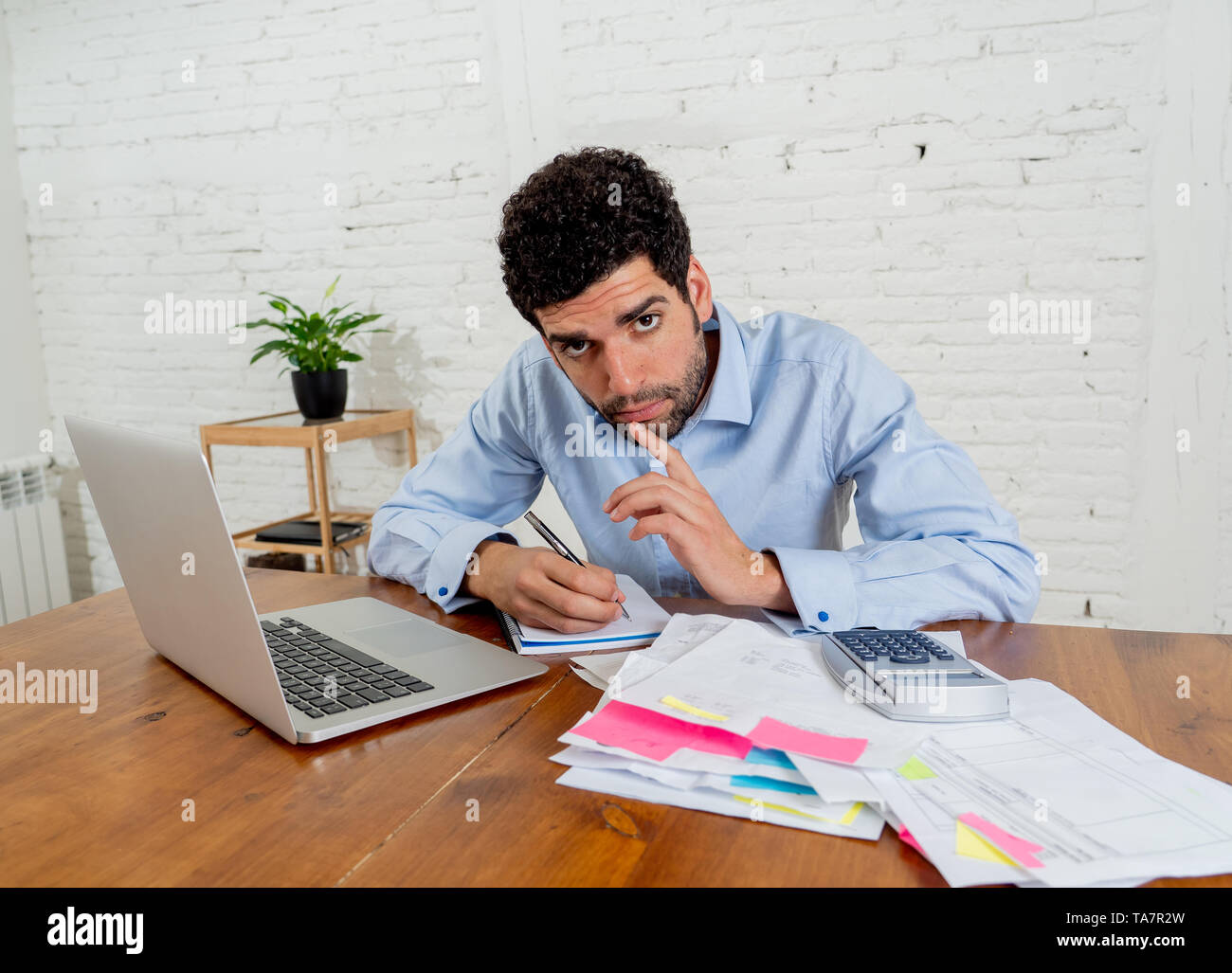 Junge Unternehmer Kleinunternehmer Zahlen von Rechnungen und Aufwendungen mit Geld Probleme. Wütend und verzweifelten Mann Stress während w Stockfoto