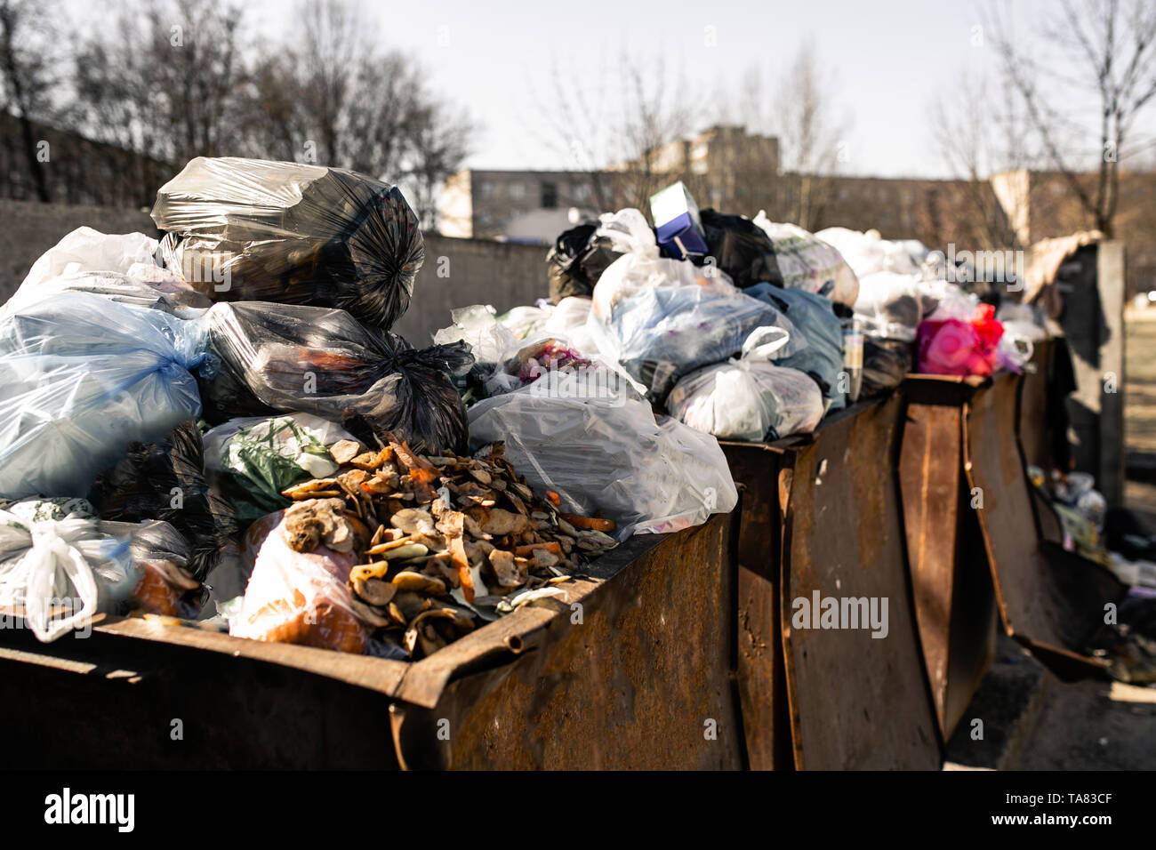 Mülltonnen sind mit Pakete mit Abfall überfüllt Stockfoto