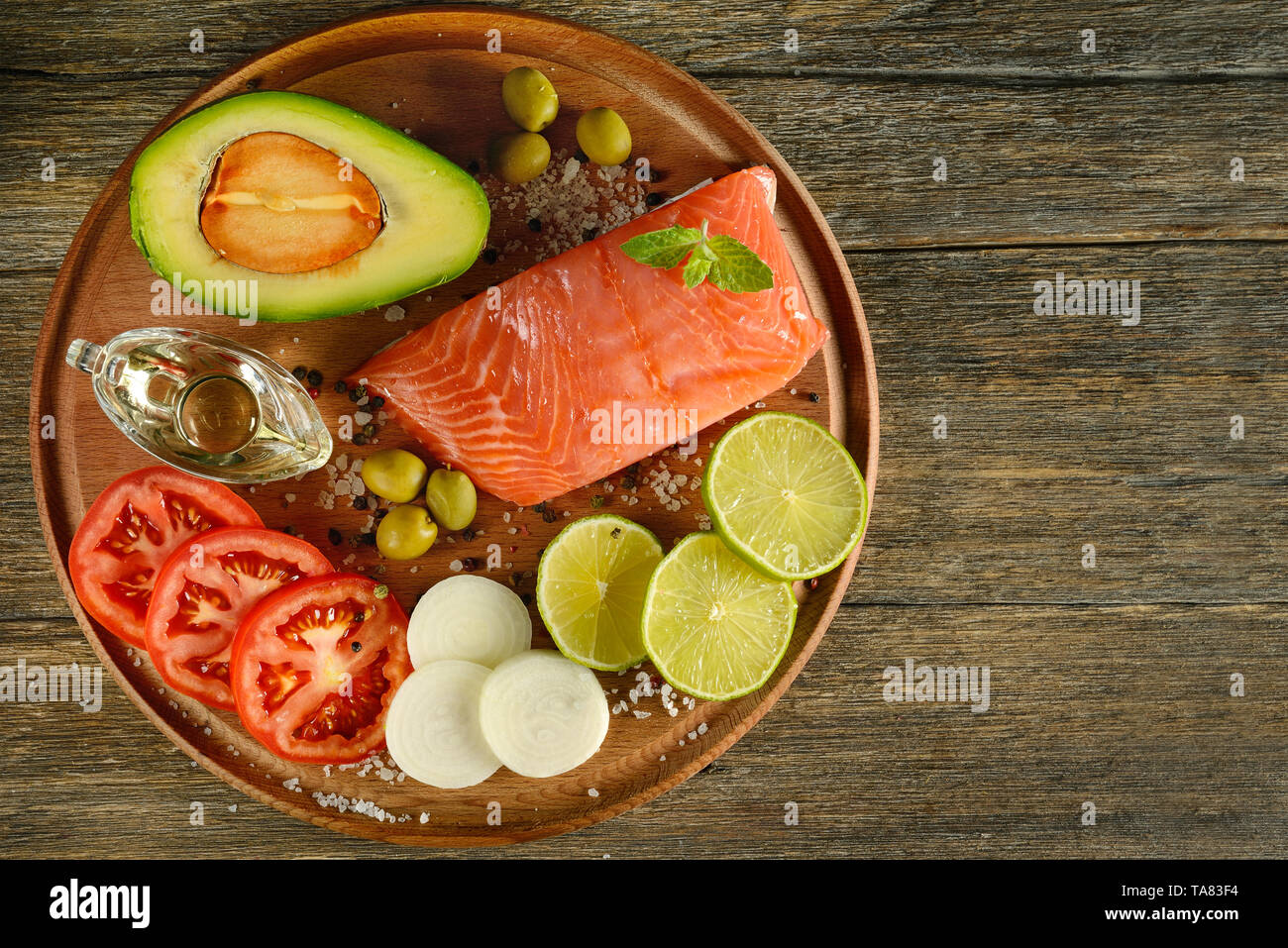 Fleisch rot Lachs Fisch, Tomaten, Gewürze, Zitrone, grüne Oliven auf hölzernen Küchentisch. Kopieren Sie Platz. Stockfoto