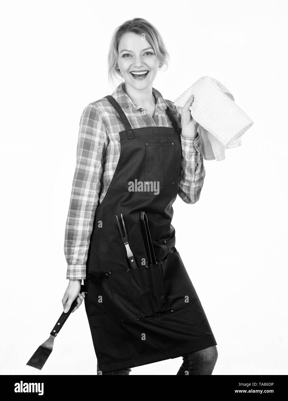 Hübsches Mädchen in Koch Schürze. Vorbereitung und Kulinarisches. Frau halten Küchengeräte. Tools für Braten outdoor. Picknick Grill. Essen kochen Rezept. Wochenende mit der Familie. Leckeres Essen und gute Gesellschaft. Stockfoto