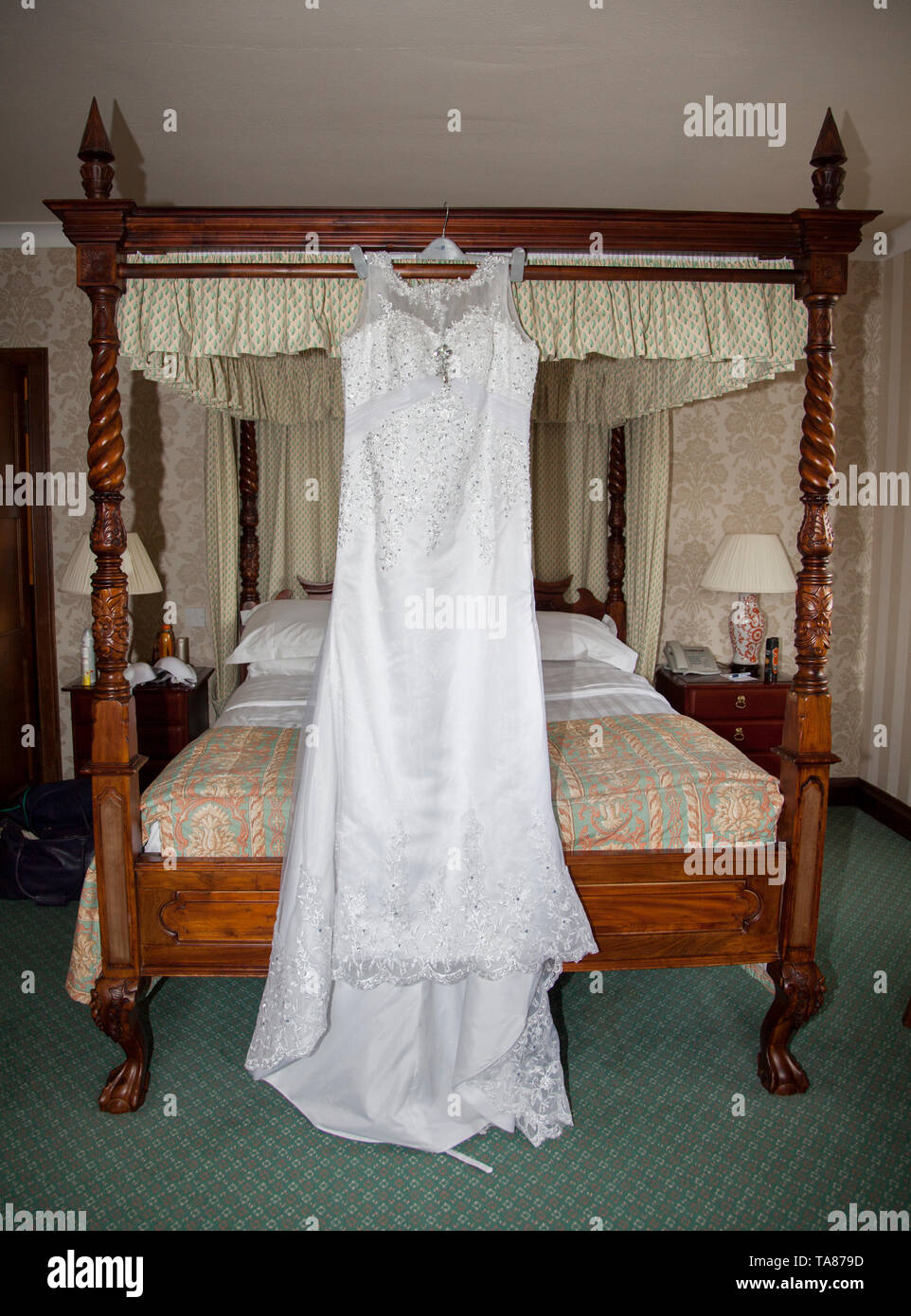Bräute Hochzeit Kleid Auflegen mit Schuhen und Blumen an der Vorderseite des Foto, warten Alle getragen zu werden von der Braut an ihrem Hochzeitstag. Stockfoto