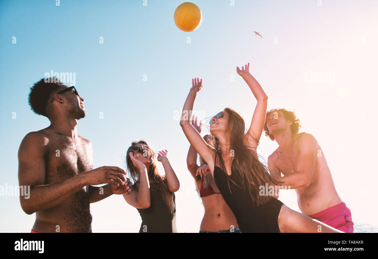 Gruppe von Freunden zu Beach-Volleyball am Strand spielen Stockfoto