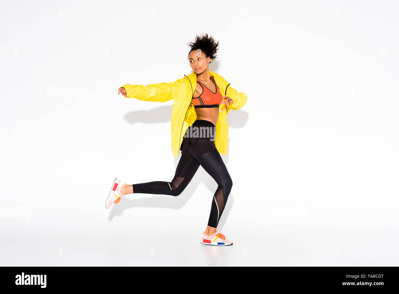 Athletische afrikanische amerikanische Sportlerin Sport Jacke in Gelb auf Weiß Stockfoto