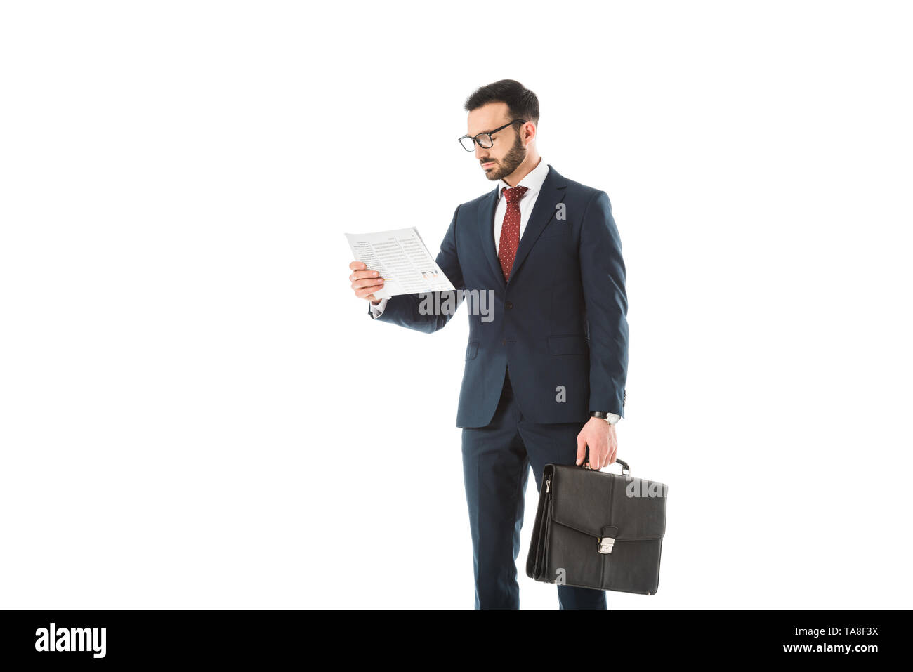 Konzentrierte Geschäftsmann mit Aktenkoffer lesen Zeitung isoliert auf weißem Stockfoto