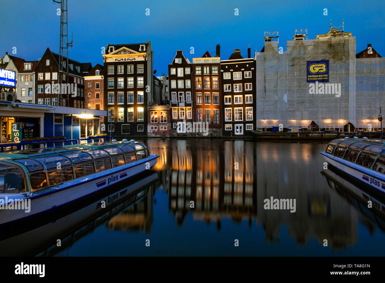 Damrak Grachtenhäuser bei Nacht - Amsterdam Canal House Reflexion tanzen Häuser von Damrak Reflexionen in der Nacht - reflektierende Häuser canal Damrak. Stockfoto