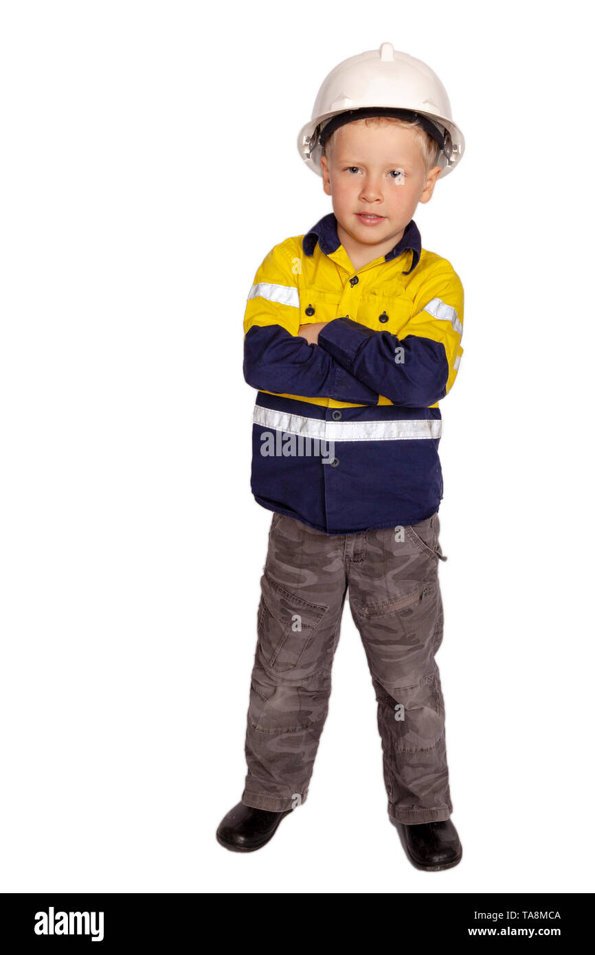 Junge blonde kaukasischen junge Arme Rolle spielen als wütende Bauarbeiter in einem gelben und blauen Hi-viz Shirt, Stiefel, weißen harten Hut, ein Hammer Stockfoto